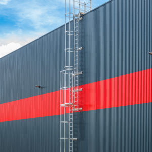 Ladder with safety cages on industrial building